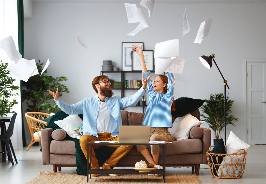 married couple with bills receipts documents and laptop at home