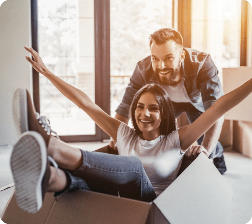 Young couple having fun man pushing woman in box