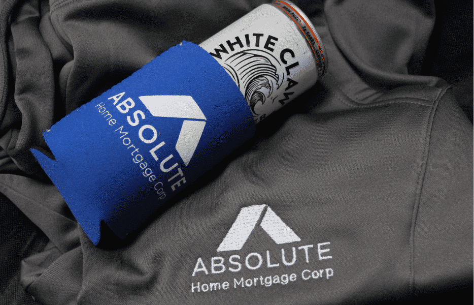 Absolute Home Mortgage beer koozie on top of Absolute Home Mortgage jacket