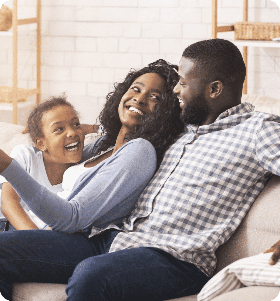 Young family sitting on the couch smiling at each other