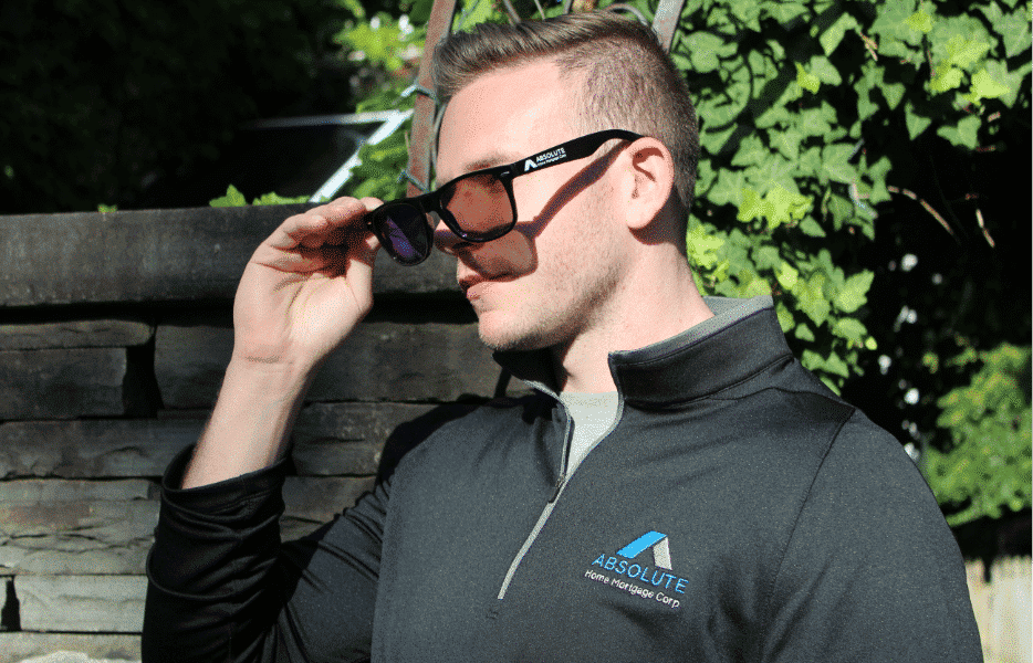 Young man wearing Absolute Home Mortgage sweatshirt and sunglasses